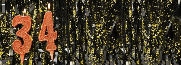 Parlak süslemeli arka planda kırmızı doğum günü mumları yakmak, 34 numara. Pankart. Boşluğu kopyala