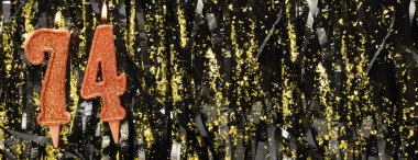 Simli arka planda kırmızı doğum günü mumları yakmak, 74 numara. Pankart. Boşluğu kopyala