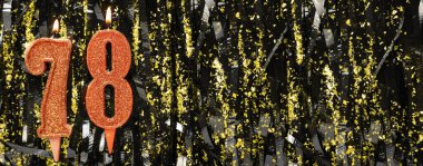 Işıltılı arka planda kırmızı doğum günü mumları yakmak, 78 numara. Pankart. Boşluğu kopyala