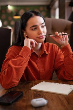 Dergi makalesi için en iyi fikirlere dikkat çeken düşünceli kadın yazarlar kişisel günlük planlama stratejileri, kafede çalışma. Boşluğu kopyala