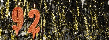 Simli arka planda kırmızı doğum günü mumları yakmak, 92 numara. Pankart. Boşluğu kopyala