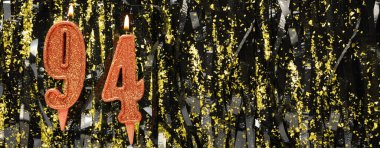 Simli arka planda kırmızı doğum günü mumları yakmak, 94 numara. Pankart. Boşluğu kopyala