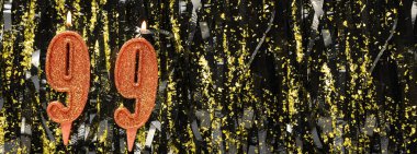 Simli arka planda kırmızı doğum günü mumları yakmak, 99 numara. Pankart. Boşluğu kopyala