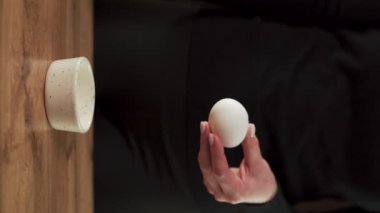 Genç aşçı yumurta sarısını küçük bir kaseye düşürüyor. Kurabiye ve hamur işi yapmak için ham malzeme hazırlıyorum. Ev yapımı yemek kavramı. Dikey video