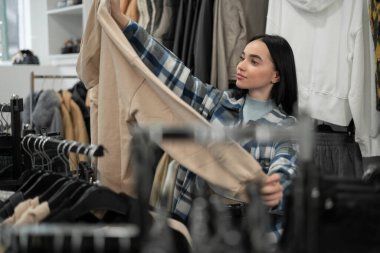 Moda mağazasından kıyafet alan güzel bir kız. Alışveriş merkezinde alışveriş konsepti. Boşluğu kopyala