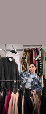 Giyim mağazasında kazak tutan genç müşteri kadın üzgün bir ifadeyle seçim için endişeleniyor. Uzayı kopyala Pankart