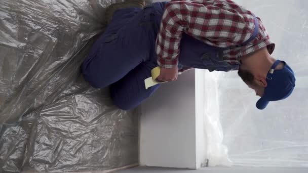 Malarz Przygotowuje Mieszkanie Remontu Naprawiacz Pokrywa Podłogę Folią Zabezpiecza Taśmą — Wideo stockowe