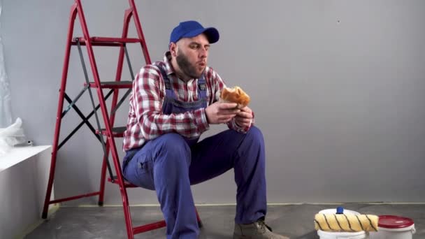 Oda Boyama Işi Hamburger Yiyen Çalışma Alanında Öğle Yemeği Yiyen — Stok video