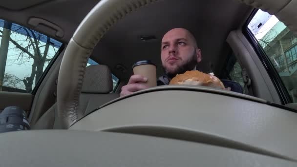 Чоловік Каву Їсть Бургер Під Час Водіння Автомобіля Під Низьким — стокове відео