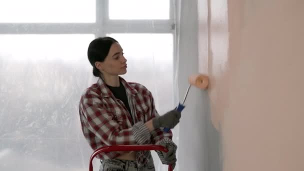 年轻美丽女子的画像 用米色粉刷粉刷墙壁 重新设计房间 家庭翻新概念 复制空间 — 图库视频影像