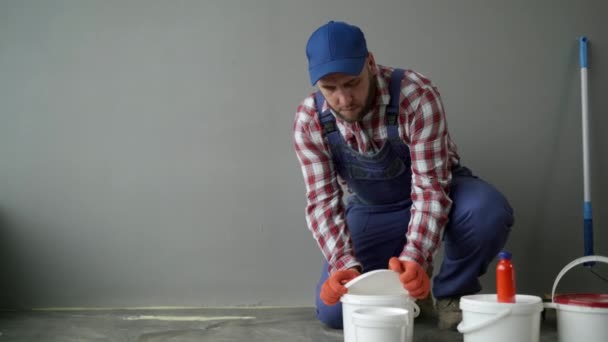 画家在白色油漆中加入橙色染料来粉刷新房子的墙壁 家庭翻新概念 复制空间 — 图库视频影像