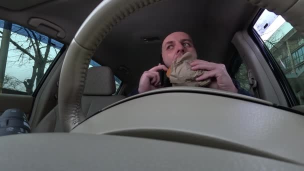 Mężczyzna Jedzący Dzwoniący Przez Telefon Siedzi Samochodzie Kierownicą Wielozadaniowy Kierowca — Wideo stockowe