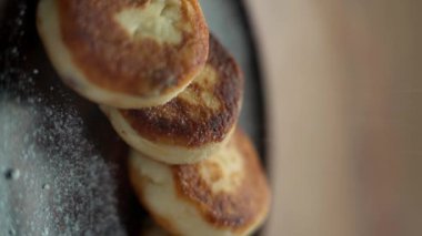 Süzme peynirli krepler tabağa pudra şekeri serpiştirilir. Lokantada krep servisi. Sağlıklı kahvaltı konsepti. Dikey video