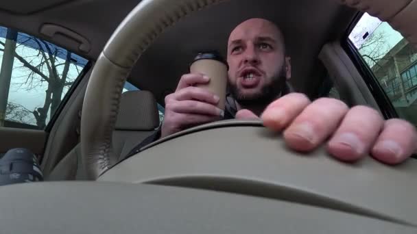 怒っている運転手はコーヒーを飲んでおり 交通渋滞で車の誰かに激しい叫び声を上げています ローアングル クローズアップ — ストック動画