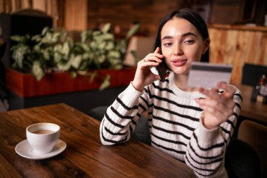 Kafede kredi kartıyla ödeyen bir kadın. Boşluğu kopyala