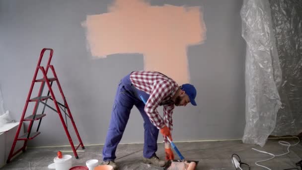 ペンキのローラーが付いているひげを付けられた労働者か絵画の壁 ホームリフォームコンセプト — ストック動画
