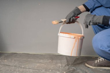 İş yerindeki boyacı kadın fırça ve kovayla, yakın plan, alt manzara. Boşluğu kopyala