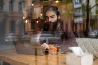 İşine odaklan. Zeki sakallı hippi bir adam kafeteryada otururken dizüstü bilgisayarla çalışıyor. Pencereden bak. Boşluğu kopyala