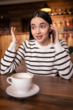 Gülümseyen esmer kadın telefonda konuşuyor. Konuşan kız gülerken cep telefonu kullanıyor. Komik bir konuşma sırasında eğlenen bir bayan. Boşluğu kopyala