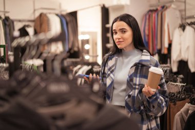 Kafası karışmış bir kız ve bir elbise mağazasında akıllı bir telefon seçim yapamaz, kıyafet seçiminde bir ikilem. Satış, alışveriş ve insanlar konsepti