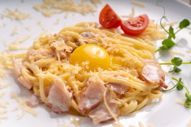 Geleneksel İtalyan makarnası veya spagetti carbonara sarısı, parmesan peyniri, beyaz tabakta pastırma, üst manzara. Boşluğu kopyala