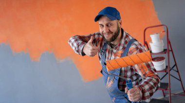 Ressam evin arka planında olumlu bir jest yapıyor. Ev yenileme ve jest konsepti