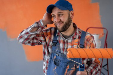 Tamirhanede duran yorgun ve hasta suratlı bir ressam. Boşluğu kopyala