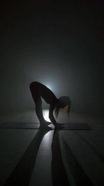Arka planda buharla yoga yapan bir kadın silueti. Sakin ol ve rahatla, kadın mutluluğu. Boşluğu kopyala