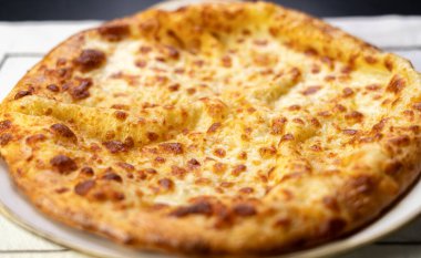 Khachapuri, beyaz tabakta sulguni peyniri ile. Megrelian Khachapuri, yakın plan. Geleneksel Gürcü mutfağı kavramı. Boşluğu kopyala