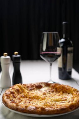 Masada kırmızı şaraplı peynirli Khachapuri, beyaz tabakta Megrean Khachapuri, Gürcistan mutfağı menüsü konsepti. Boşluğu kopyala