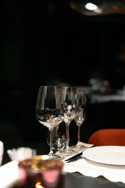 Table settings for fine dining with glassware, dark blurred background. For events, weddings, birthdays and celebrations. Copy space