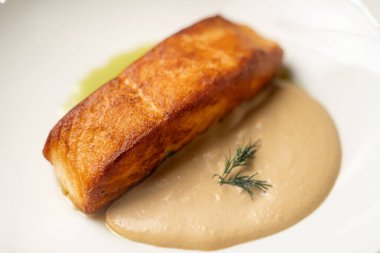 Beyaz tabakta iki soslu ızgara somon, yakın plan.