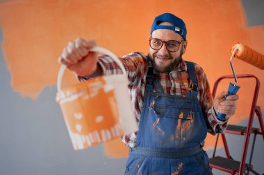 Elinde kova ve boya silindiri olan çılgın bir ressamın portresi. Duygular, yüz ifadeleri ve insanlar. Boşluğu kopyala