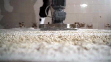 Erkek işçi, temizlik halısı temizleme makinesi kullanıyor. Yakın plan.