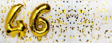 Altın folyo balon numarası, konfeti arka planında 46 numara. 46. yaş günü kartı. Yıldönümü konsepti. Doğum günü, yeni yıl kutlaması. afiş, boşluğu kopyala.