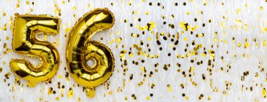 Altın folyo balon numarası, konfeti arkaplanlı beyaz balon sayısı 56. 56. Doğum günü kartı. Yıldönümü konsepti. Doğum günü, yeni yıl kutlaması. afiş, boşluğu kopyala.