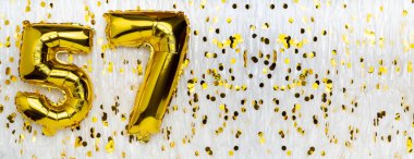 Altın folyo balon numarası, konfeti arka planında 57 numara. 57. doğum günü kartı. Yıldönümü konsepti. Doğum günü, yeni yıl kutlaması. afiş, boşluğu kopyala.