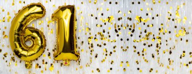 Altın folyo balon numarası, 61 numara konfeti arka planında. 61. Doğum günü kartı. Yıldönümü konsepti. Doğum günü, yeni yıl kutlaması. afiş, boşluğu kopyala.