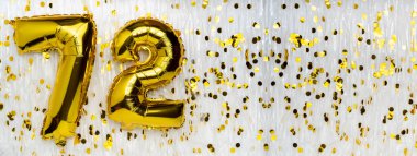 Altın folyo balon numarası, 72 numara konfeti arka planında. 72. Doğum günü kartı. Yıldönümü konsepti. Doğum günü kutlaması. Pankart