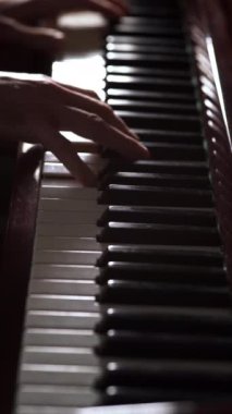 Karanlıkta klavye çalan bir piyanistin yakın çekimi. Müzik aletleri ve eğlence konsepti. Dikey video