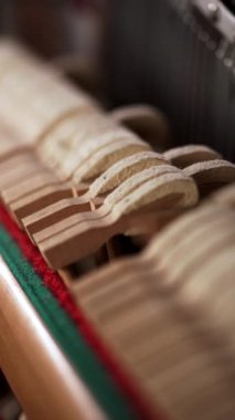 Piyanonun içinde. Telli eski klasik piyano çekiçleri, yakın plan. Dikey video