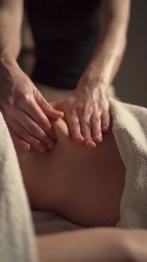 Masajcı kadın karnında kilo kaybı için lenfatik drenaj masajı yapıyor. Dikey video. Yakın plan.