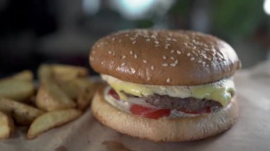 Garson ziyaretçilere büyük lezzetli hamburgerlerle restoranın içinde parlak ışıklandırmalı patates kızartması getiriyor. Fast Food ve yeme konsepti. Seçici odak