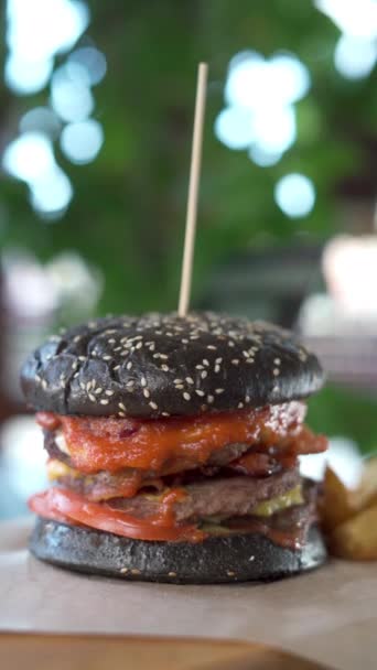 Lekkere Sappige Grote Zwarte Hamburger Met Verse Ingrediënten Die Draaien — Stockvideo