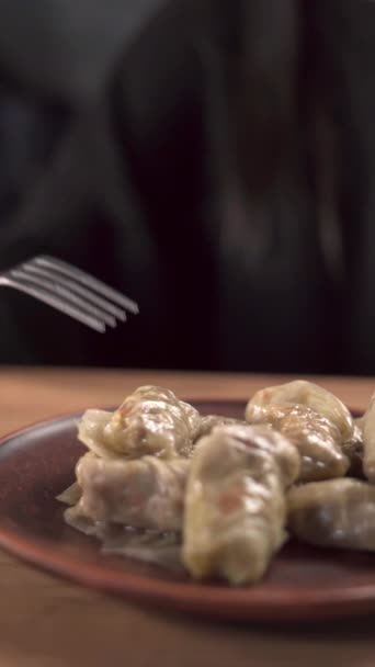 おいしい詰め物キャベツロールはサワークリームで食べて クローズアップします 垂直ビュー — ストック動画