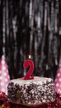 2 numaralı doğum günü mumu masadaki tatlı kekin üzerinde, 2. doğum günü pastası. Bayram mumunu üfle. Boşluğu kopyala