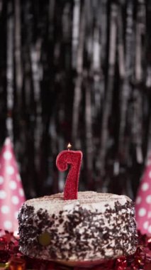 Yedi numaralı doğum günü mumu masadaki tatlı kekin üzerinde, yedinci yaş günü. Bayram mumunu üfle. Boşluğu kopyala