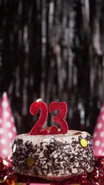 Pastada 23 numaralı mumları yakmak. 23 yaş için doğum günü pastası. Ağır çekim. Boşluğu kopyala