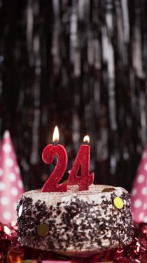 Pastada 24 numaralı mumları yakmak. 24 yaşındakiler için doğum günü pastası. Ağır çekim. Boşluğu kopyala