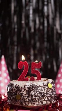 Pastada 25 numaralı mumları yakmak. Yirmi beş yaşındaki için doğum günü pastası. Ağır çekim. Boşluğu kopyala